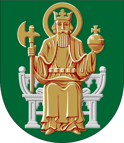Municipal heraldry of Ulvila, depicting St. Olaf in gold seated on a silver throne with axe and cross-bearing orb in hand against a green background.